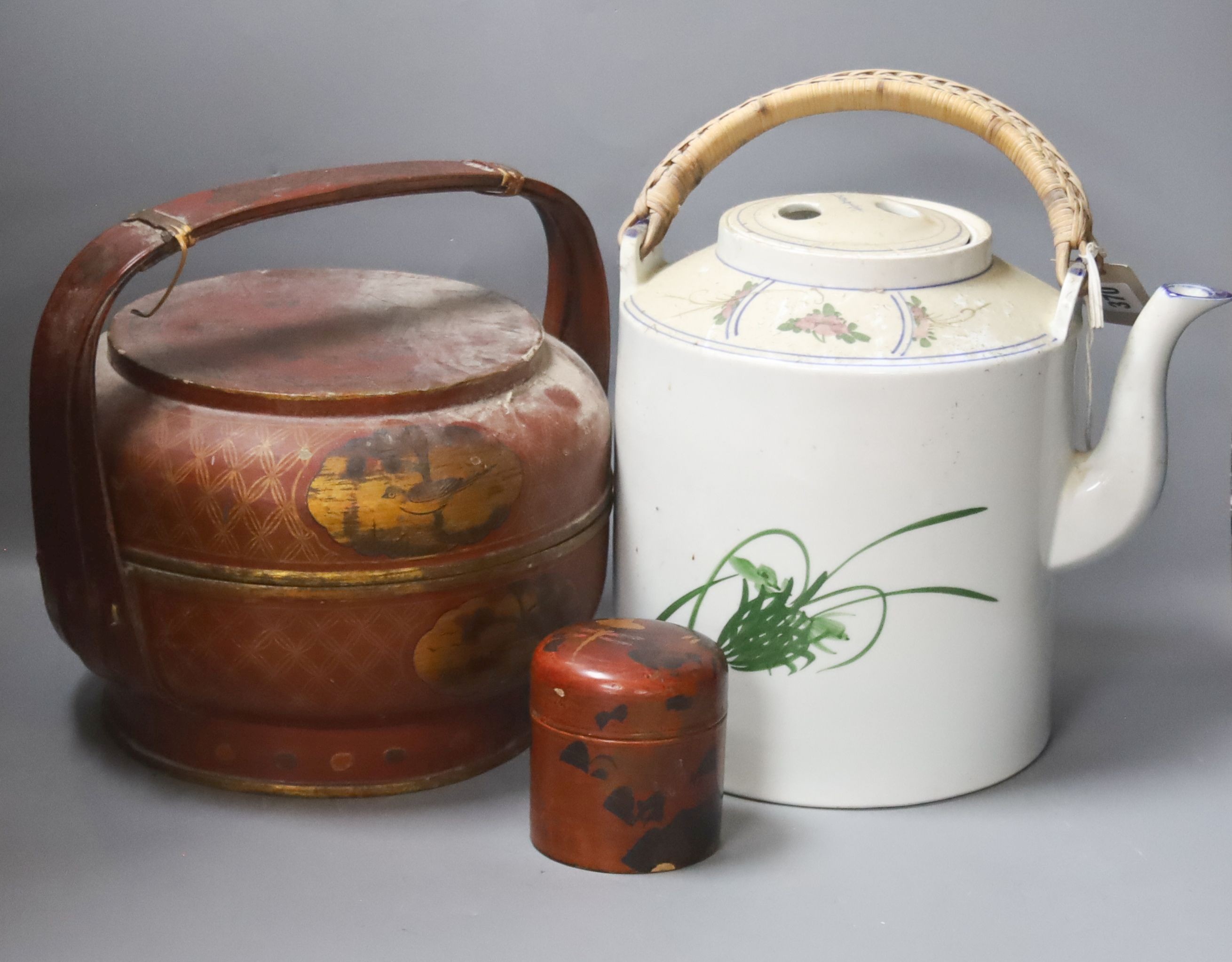 A Chinese large cylindrical porcelain teapot, with bamboo handle and polychrome-decorated with flowers and birds, H 24cm, together with two Japanese red-lacquered containers